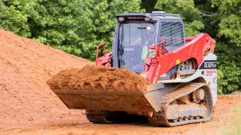 worker driving equipment at a construction site