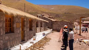 Village house with people outside. 