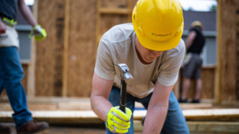Construction worker with hardhat and hammer.