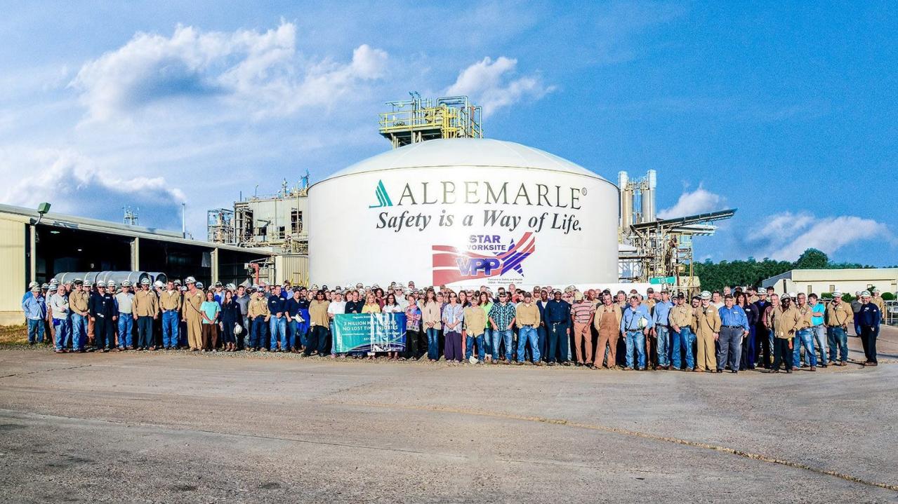 group of employees in front of safety sign