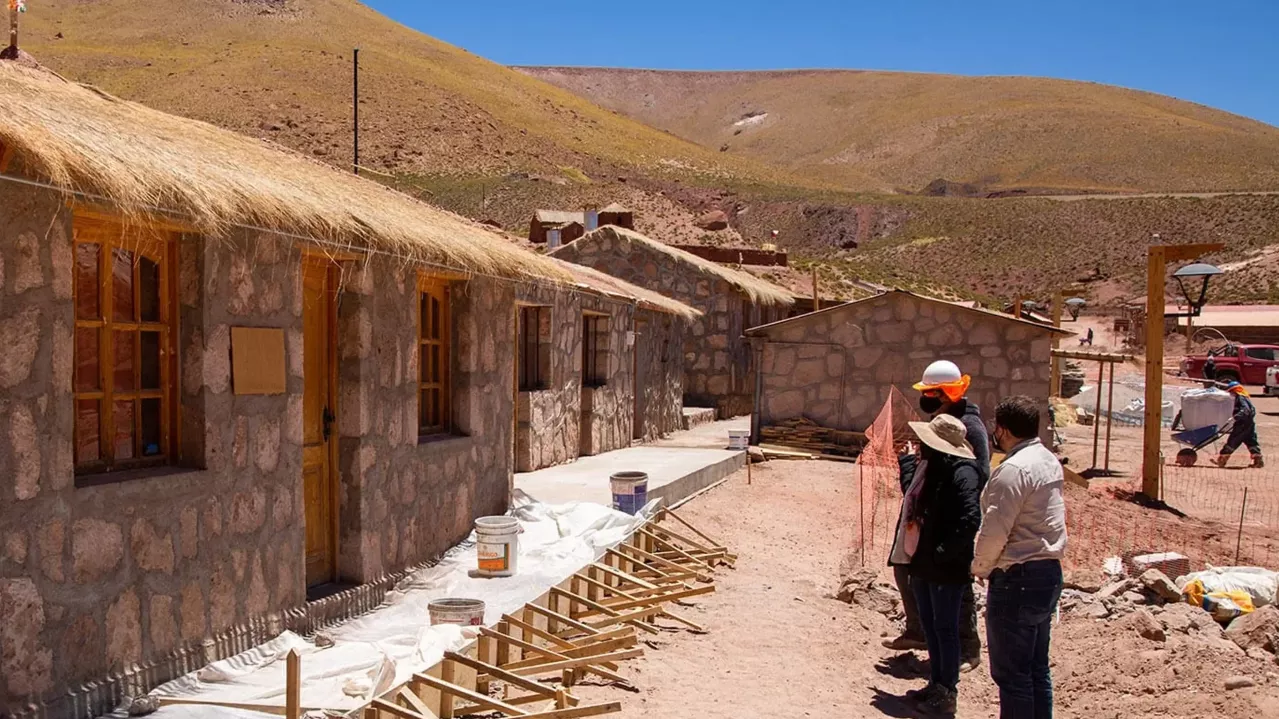 Village house with people outside. 