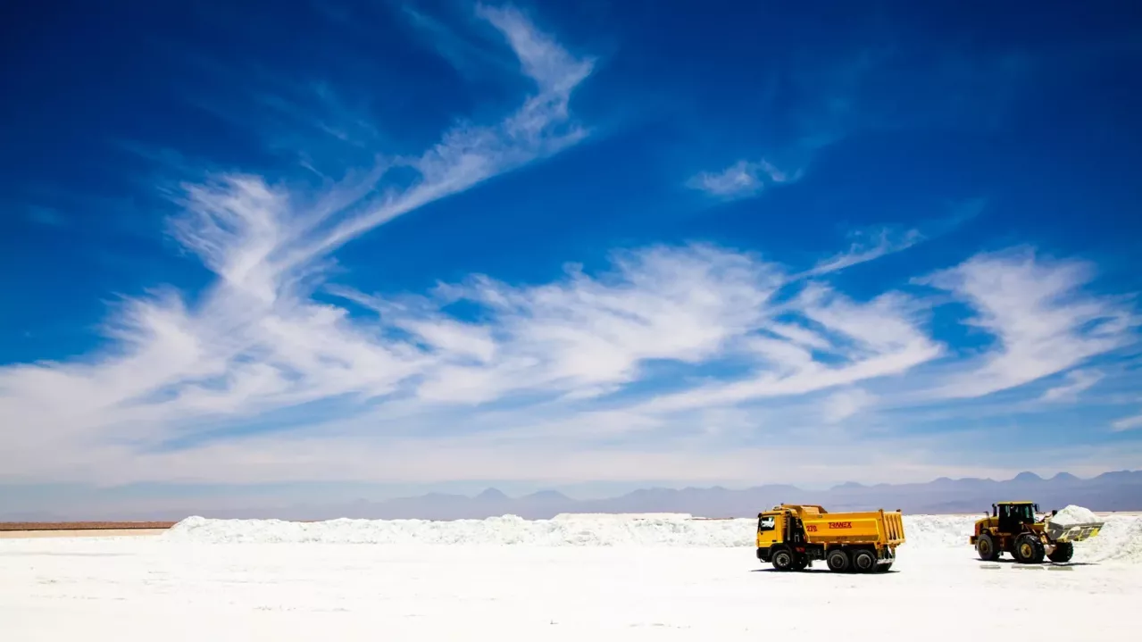 Trucks on the Salar. Deep blue sky with clouds. 