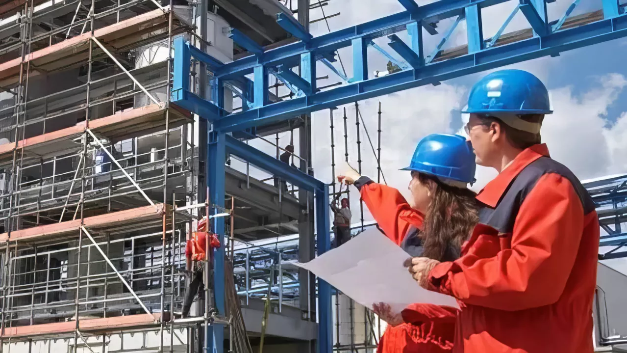 Plant workers in hardhats shown outside of the plant.