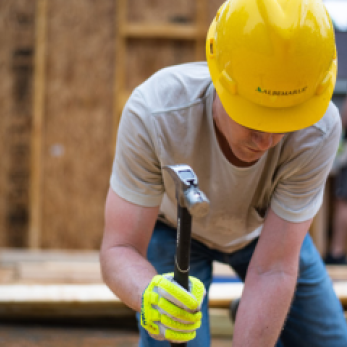 Construction worker with hardhat and hammer.