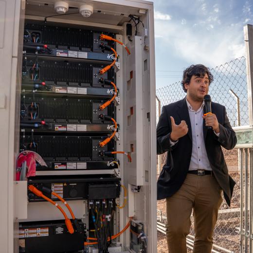 A photo of a man describing a solar energy storage system that uses lithium batteries.