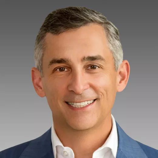 Headshot of Eric Norris, President of Energy Storage, who is smiling, has short gray hair, wearing a blue suit jacket and a light blue shirt.