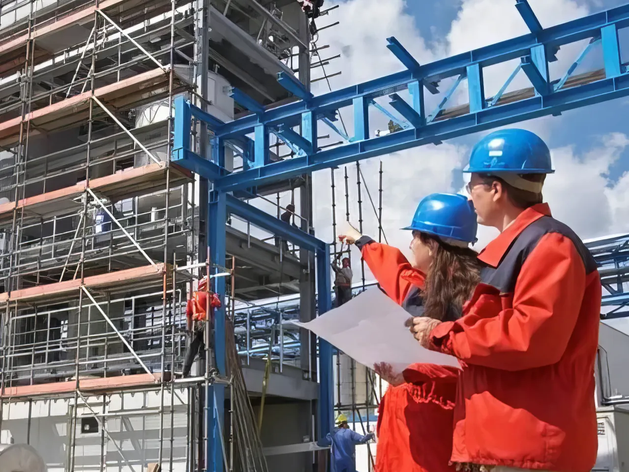 Plant workers in hardhats shown outside of the plant.