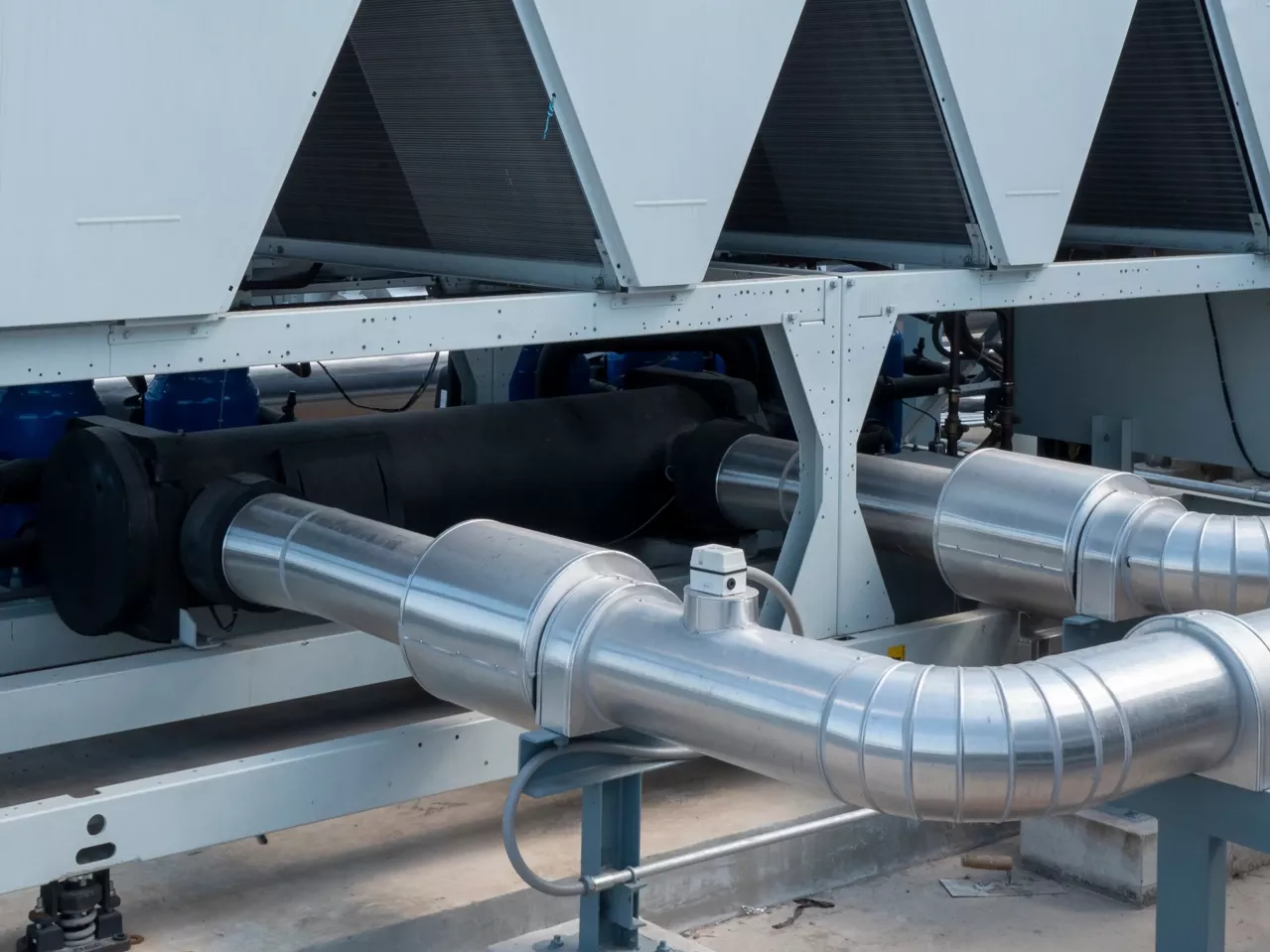 Image of industrial equipment comprising large metal pipes and machinery parts, probably pertaining to a factory setting focused on lithium, bromine, and derivative products processing.