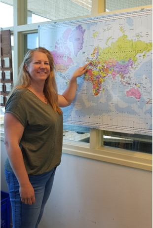 Mandy Klein-Valk points at Netherlands on a world map